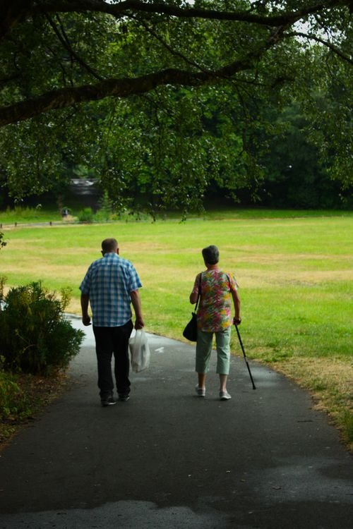 A happy couple enjoying an active walk outdoors in a green park